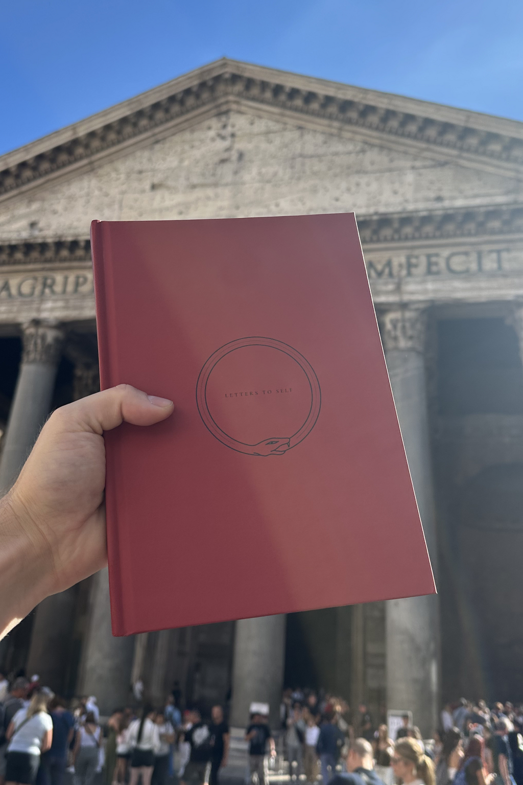 Letters To Self guided journal held up in front of the Pantheon in Rome.
